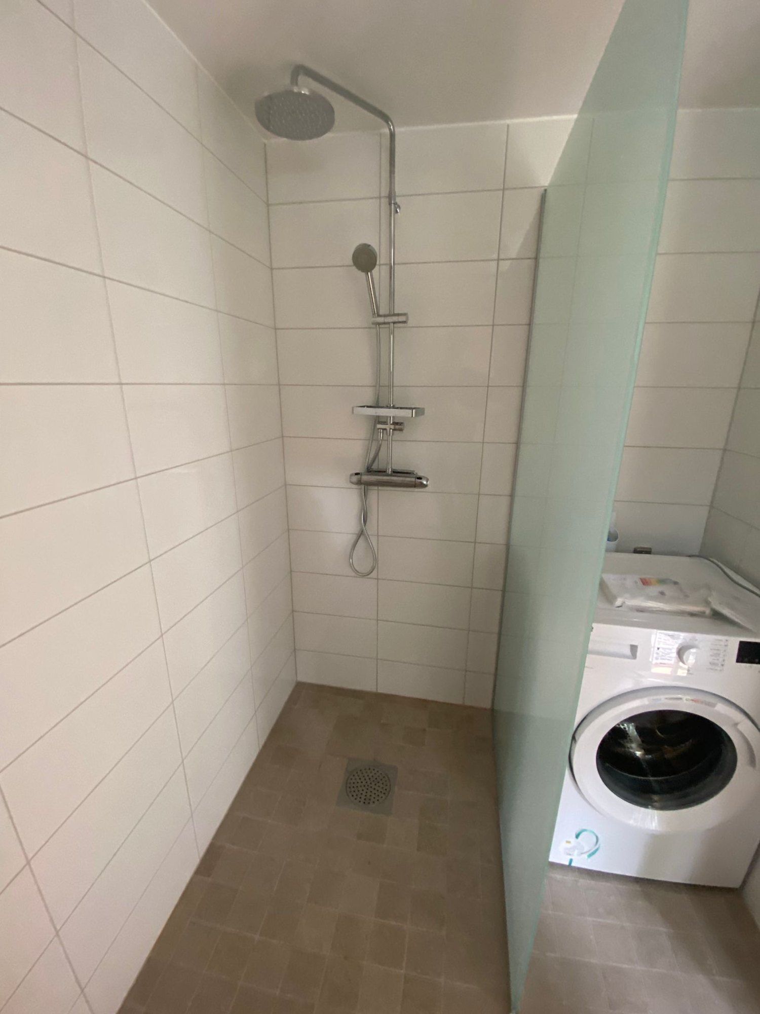Duschplats och inkopplad tvättmaskin i tvättstuga